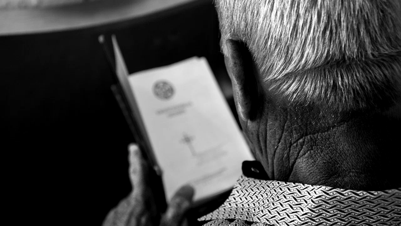 a person holding a small printed card and reading it