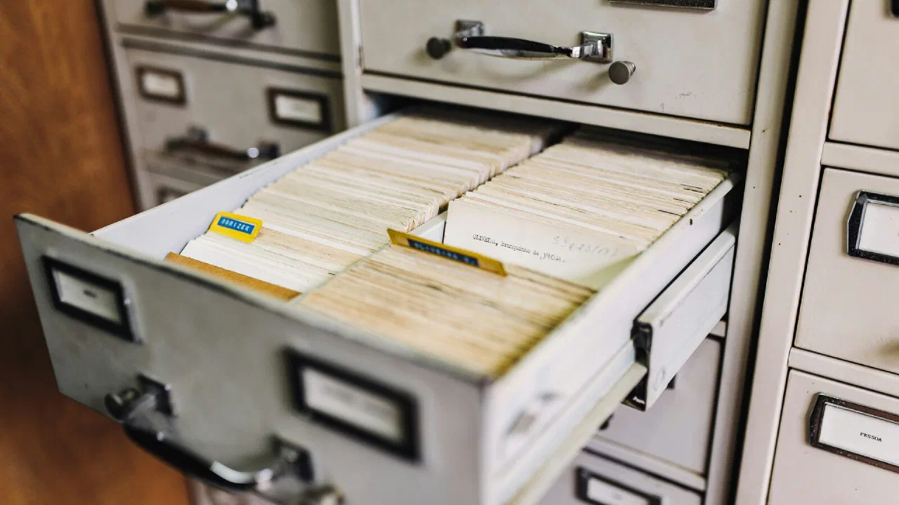 a bank of metal file cabinet drawers with paper labels